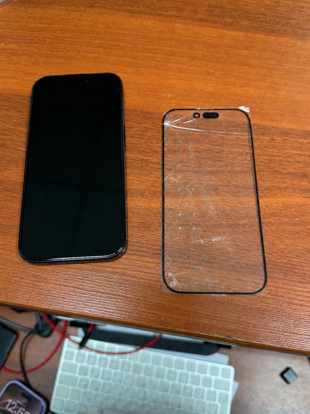 iPhone 16 Pro после замены стекла рядом со снятым разбитым стеклом
